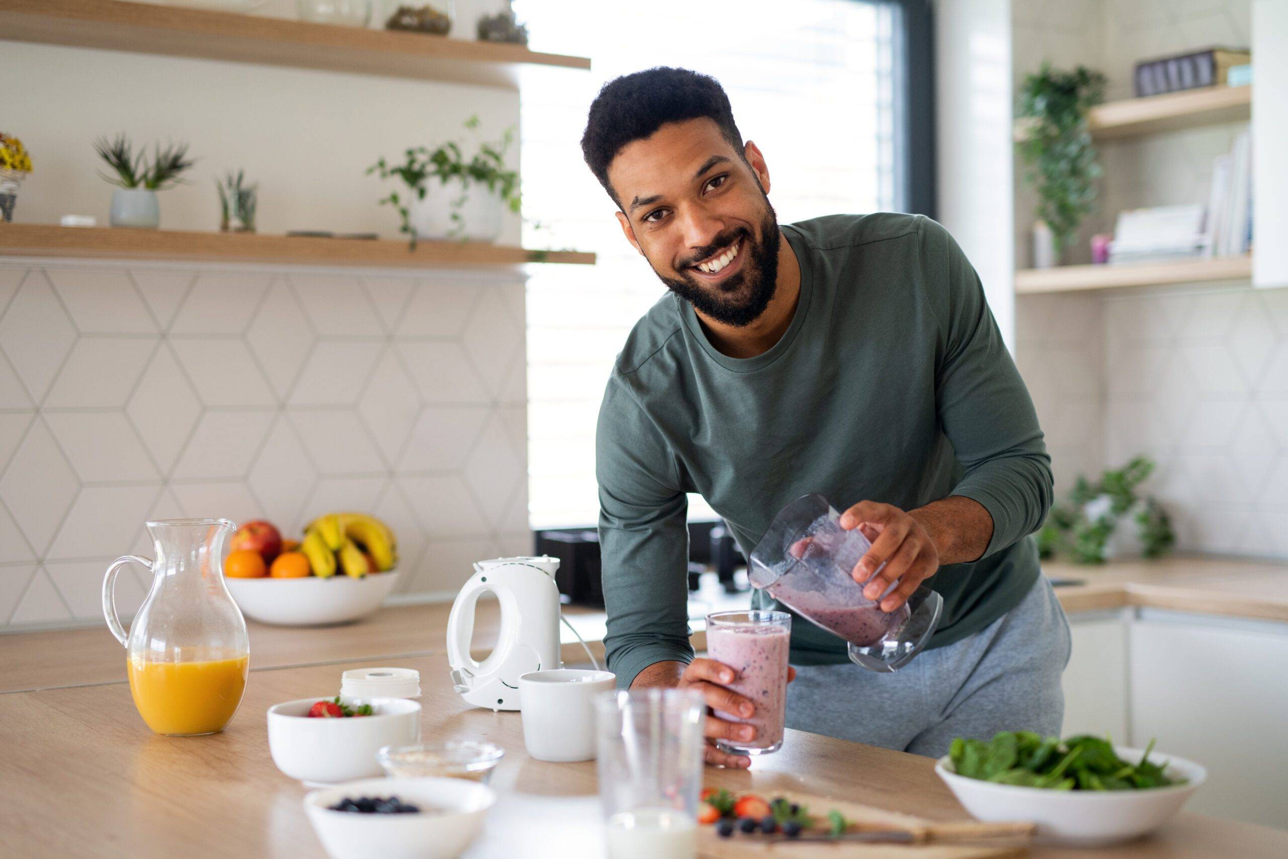 Portrait of team member Thomas Ryan who is a young man preparing healthy breakfast indoors at home, looking at camera.